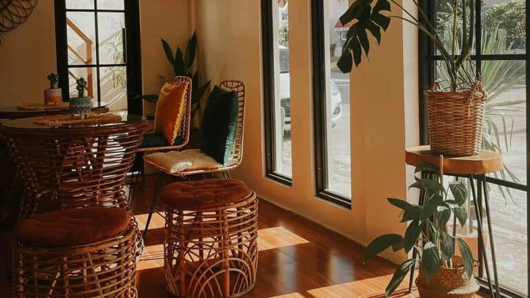 Wooden staircase with ornate carved balusters, decorative vase on step, warm lighting, and orange-toned walls