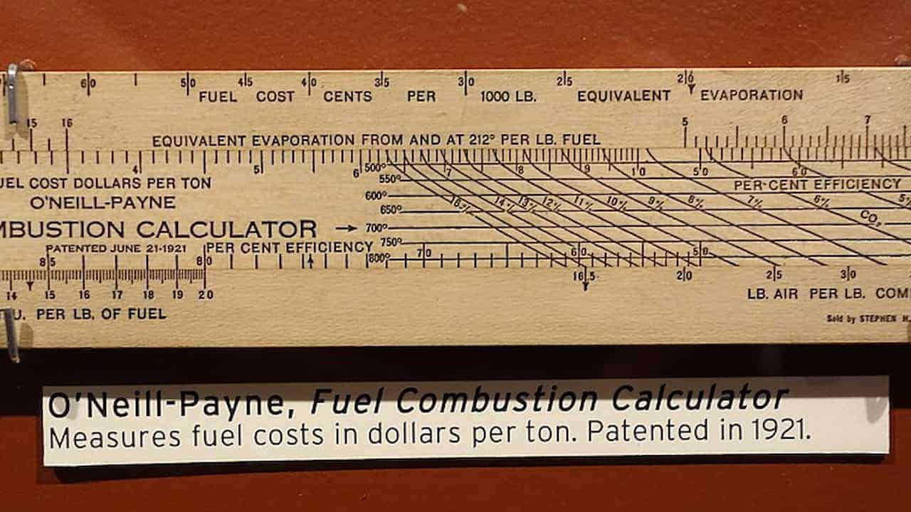 A vintage wooden slide rule labeled "O'Neill-Payne Fuel Combustion Calculator," featuring multiple linear scales and diagonal lines for calculating fuel cost, evaporation, and efficiency, with an explanatory tag noting its 1921 patent