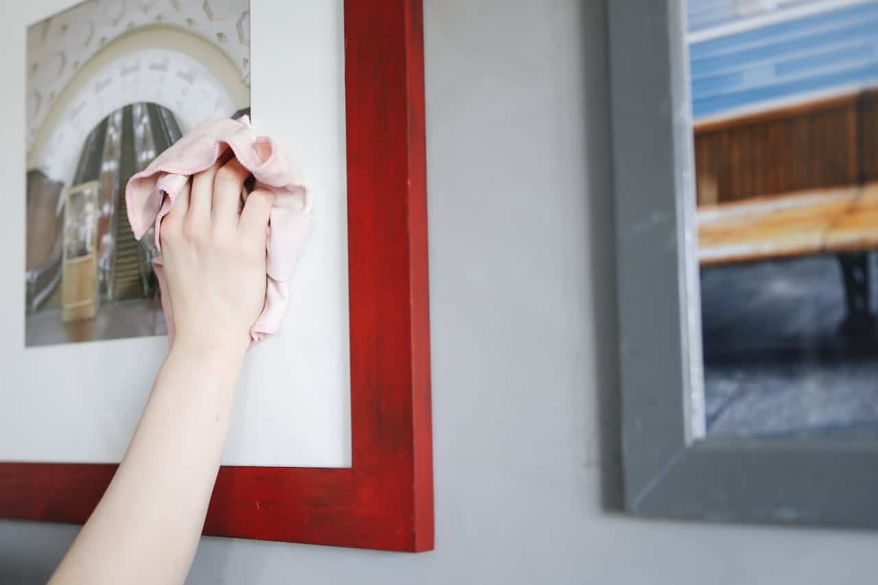 Hand cleaning photo frame, pink cloth, red wooden frame, wall-mounted picture, indoor setting