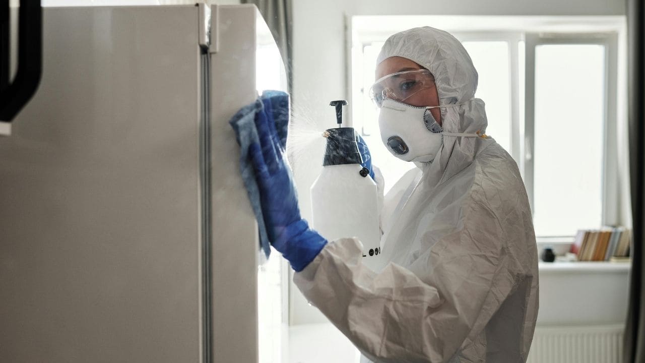 person cleaning with mask on a high touch surface door