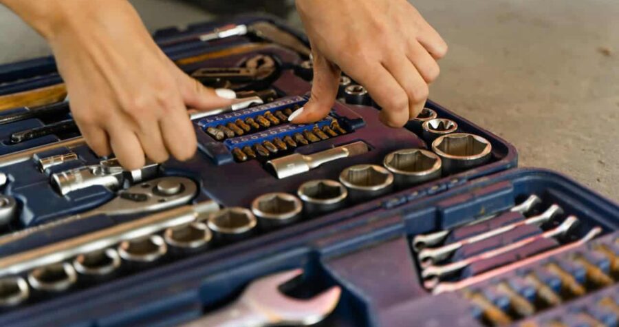 Set of assorted hand tools neatly arranged, including screwdrivers, pliers, wrenches, and a hammer