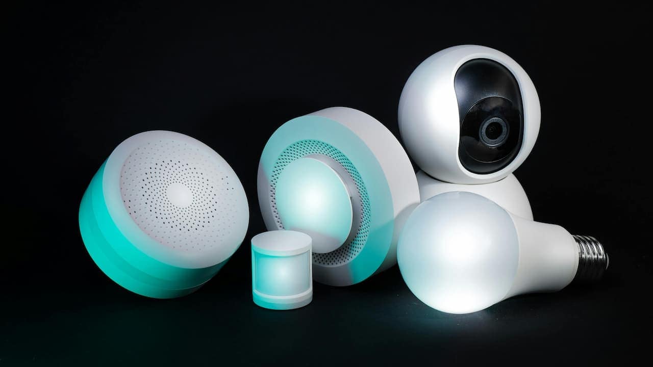 Close-up of motion sensors with sleek designs against a solid black background, illuminated softly to highlight their contours and sensors