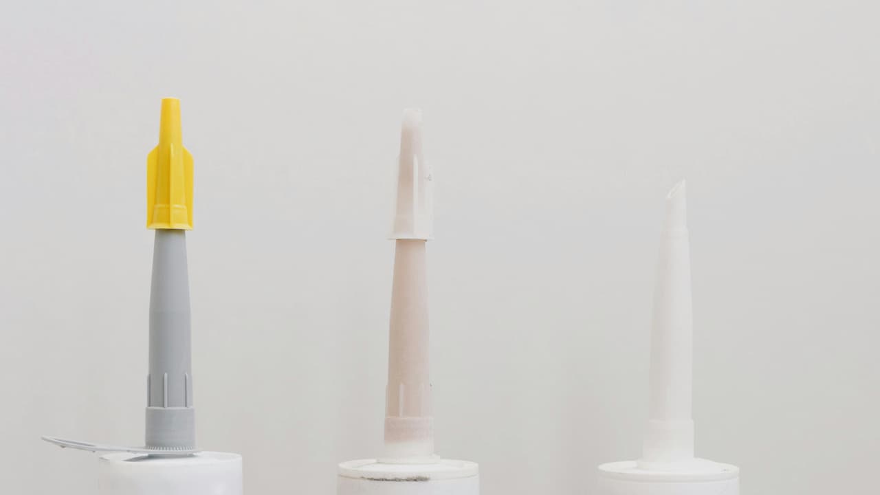 Three containers of moldable glue adhesive, small jars or tubes, labeled for craft or repair use