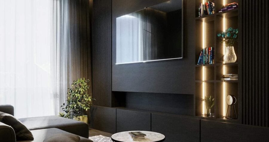 Modern living room with sleek design, large flat-screen TV mounted on a dark wall, bookshelves with dim lighting, potted plant in the corner, cozy sectional sofa with soft cushions, a marble coffee table on a patterned rug