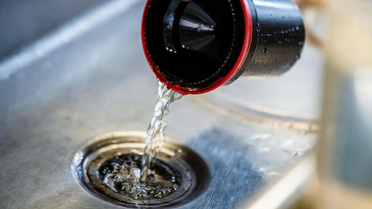 pouring drain cleaner sink