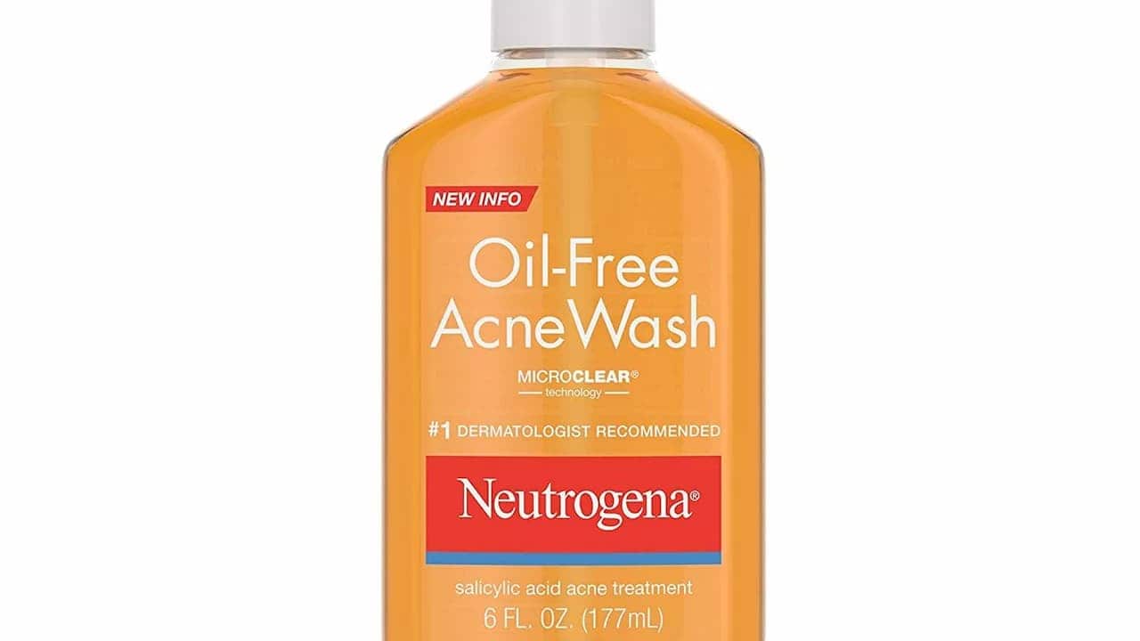 Neutrogena Oil-Free Acne Wash bottle in orange color with white cap, featuring MicroClear technology and salicylic acid treatment