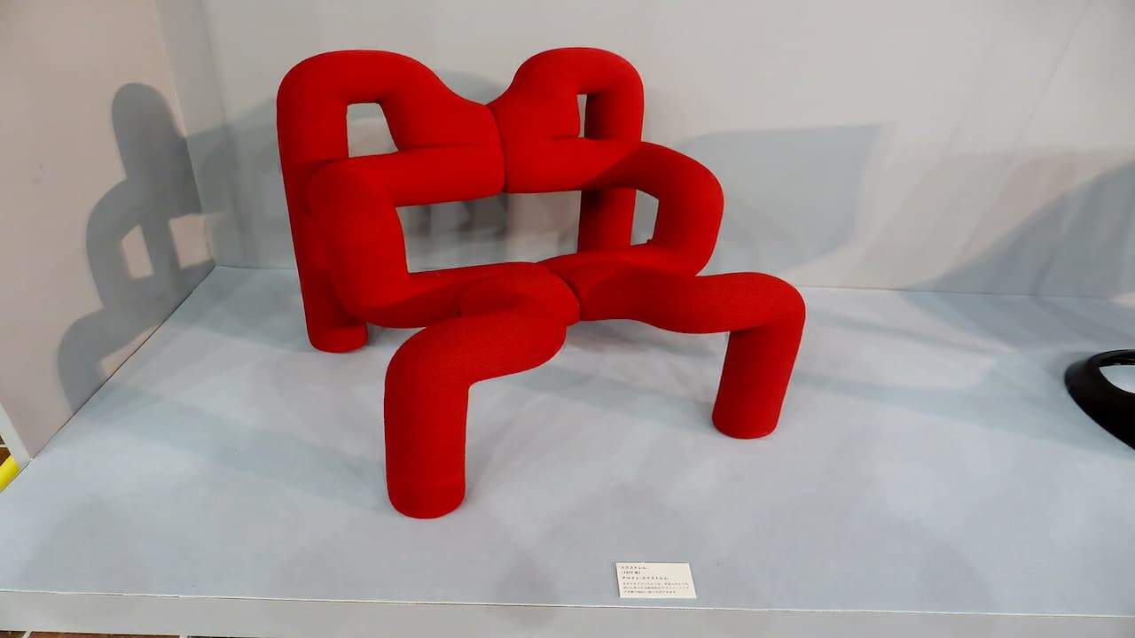 Terje Ekstrom Orange 1980s Armchairs with curved tubular frame and upholstered seat displayed on white platform in gallery setting