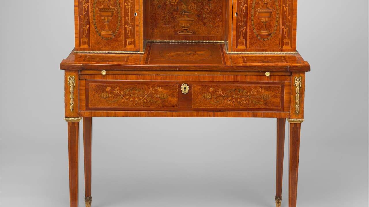Arts and Crafts Oak Desk with fold-down front, multiple compartments, inlaid decorative patterns, and brass hardware on tapered legs