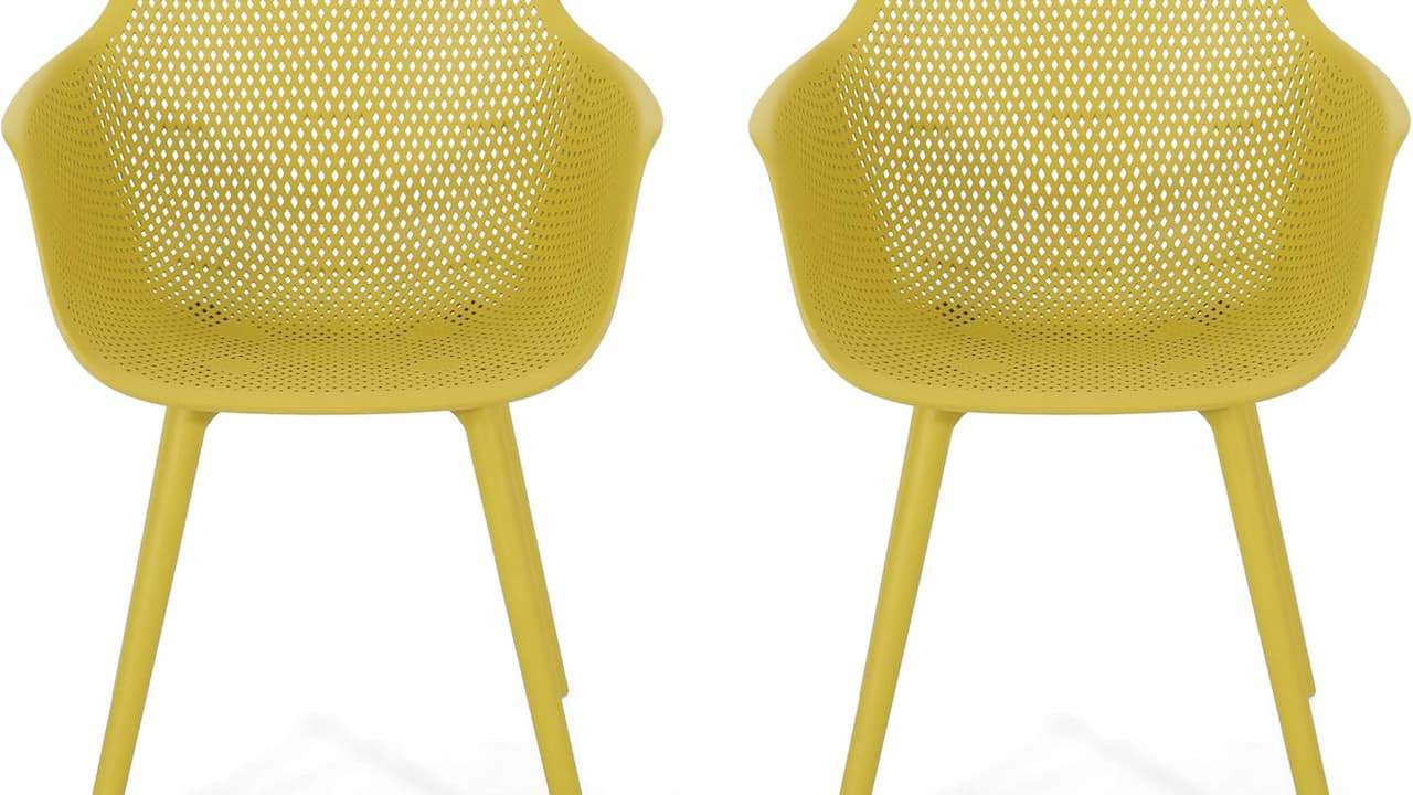 Two matching yellow perforated plastic chairs with curved armrests and angled legs on white background