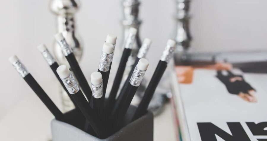 Black pencils with white erasers in a grey holder