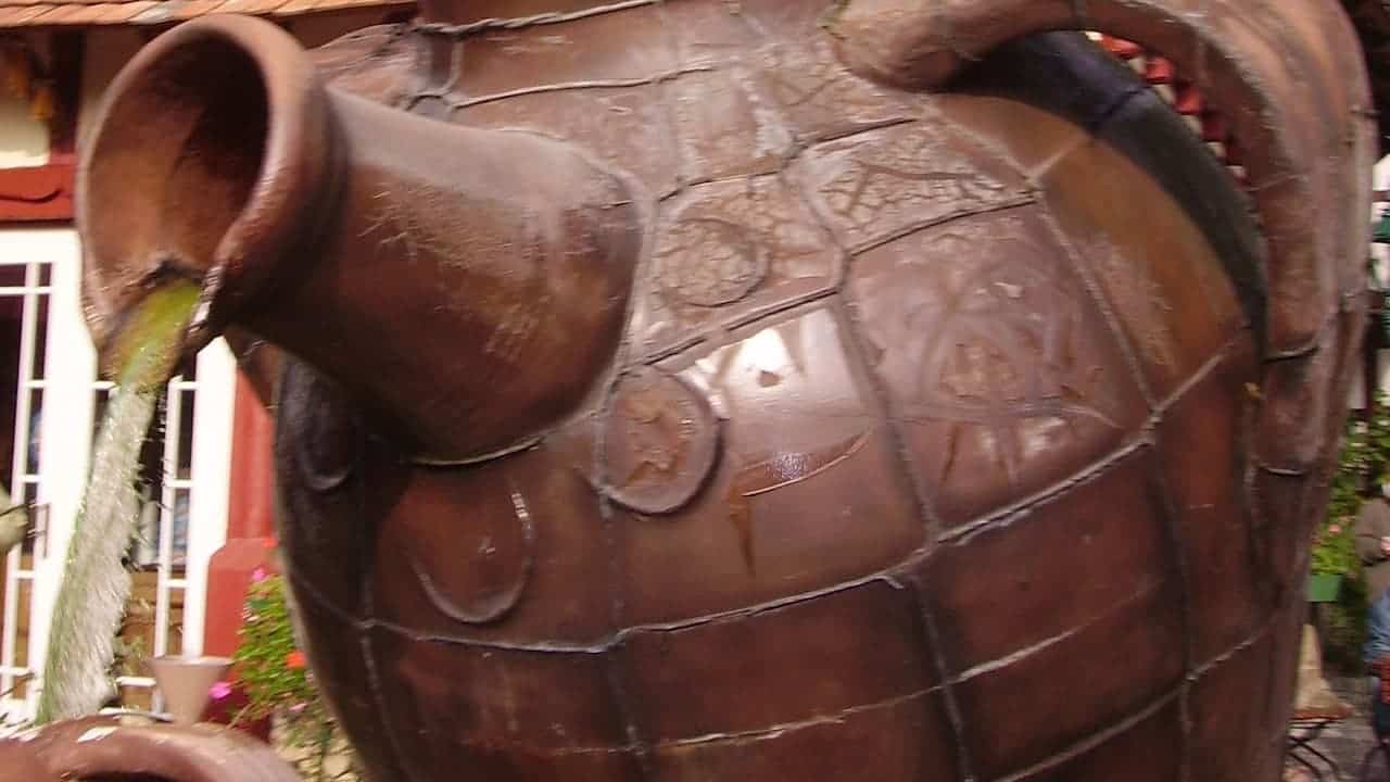A container pot fountain with water flowing gently from the top into a tiered basin