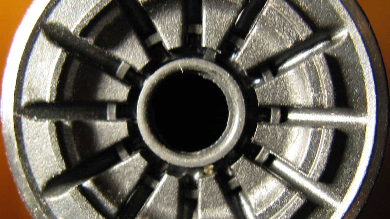 Black toilet valve installed inside a toilet tank, connected to the water supply