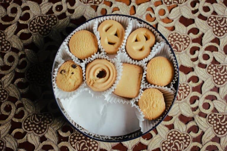 vintage biscuit tin with cookies and other pastry wrapped in white paper