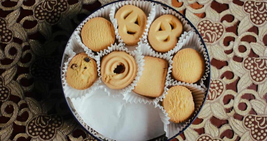 vintage biscuit tin with cookies and other pastry wrapped in white paper