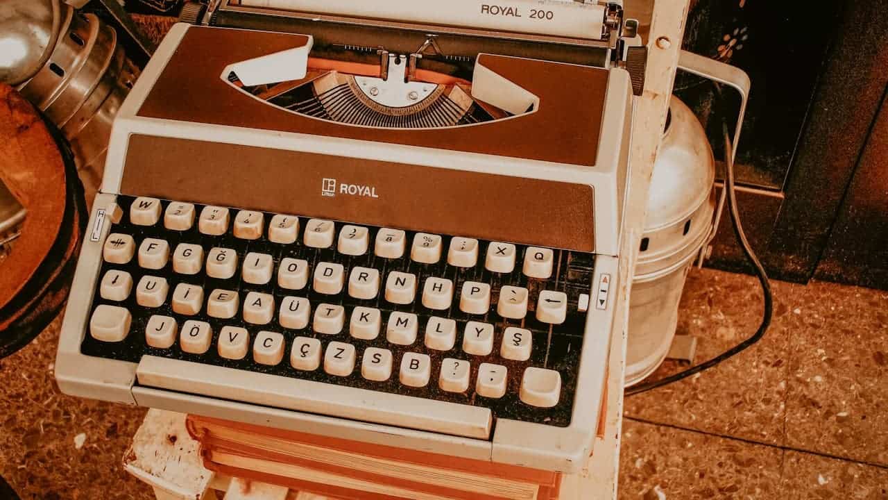 Vintage Royal 200 typewriter with white and brown casing, white keys, and QWERTY keyboard layout on wooden surface