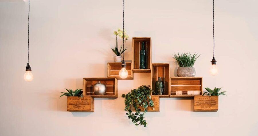 Wooden pallet mounted on wall, holding potted plants, tools slid between pallet slats, plants placed decoratively on top, space-saving, organized, eco-friendly DIY garden storage