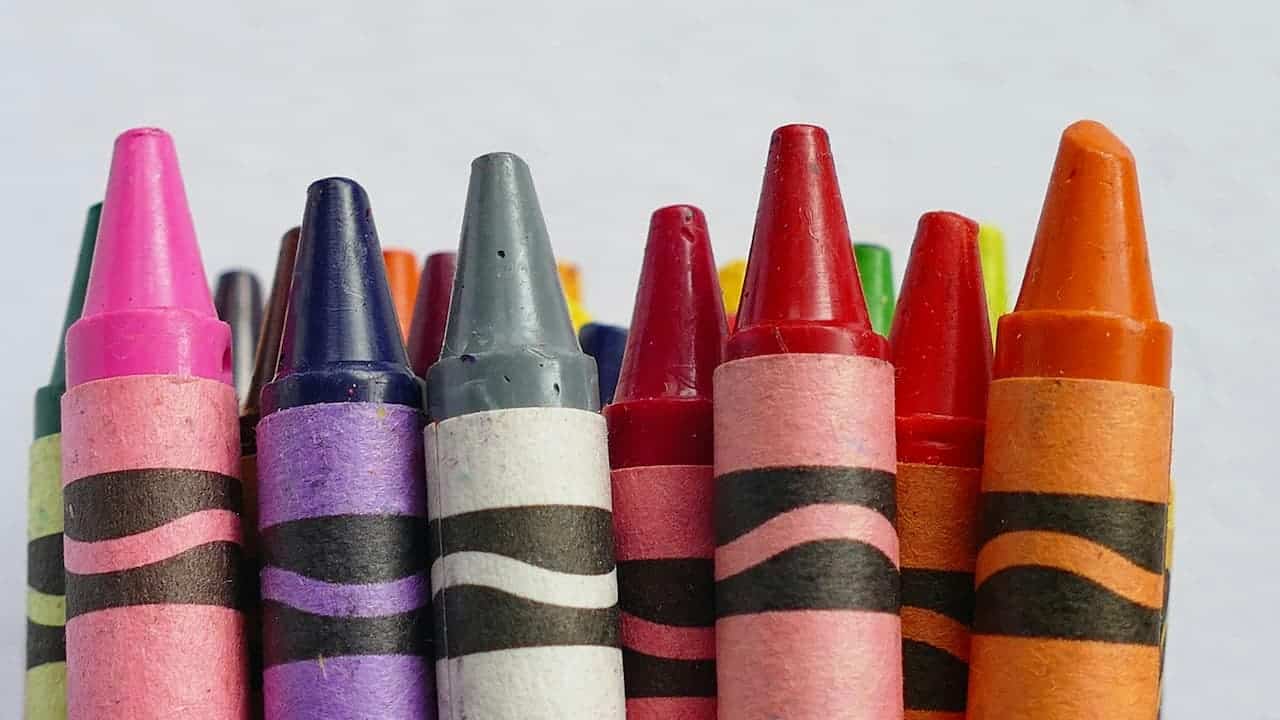 Close-up of colorful crayons arranged in a row with striped wrappers