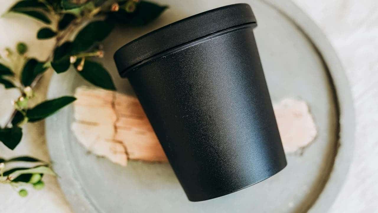 Metal drainage saucer with a shallow, circular shape and raised edges, placed under a plant pot