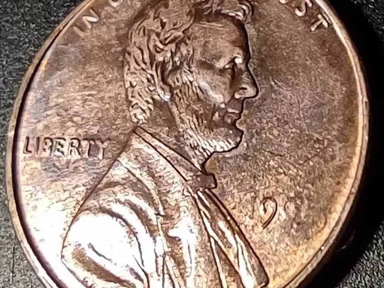 Close-up image of a worn Lincoln penny showing Abraham Lincoln's profile, the word "LIBERTY,"