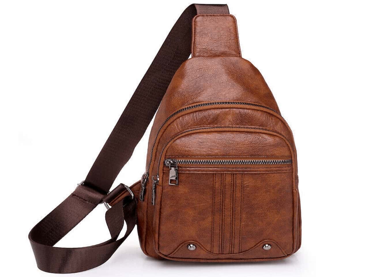 Brown faux leather sling backpack with multiple zippered compartments and a wide adjustable shoulder strap, shown against a white background