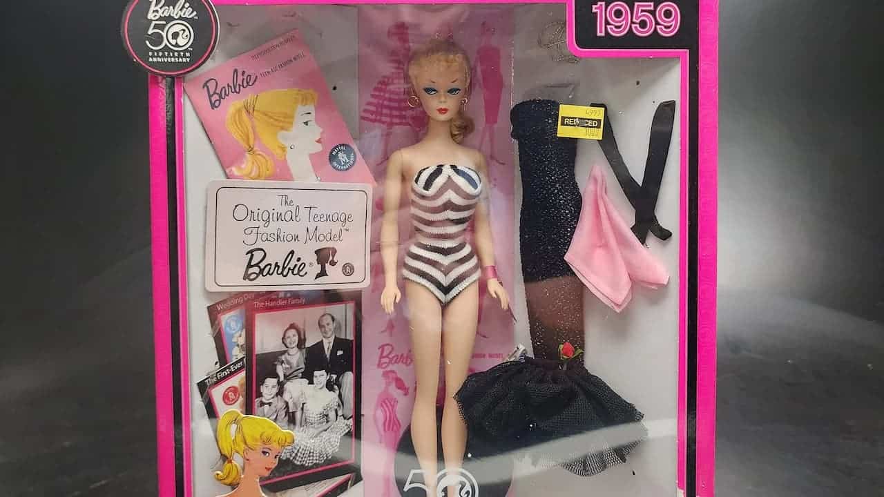 Original 1959 Barbie doll in packaging with striped swimsuit, blonde ponytail, and vintage accessories in pink box
