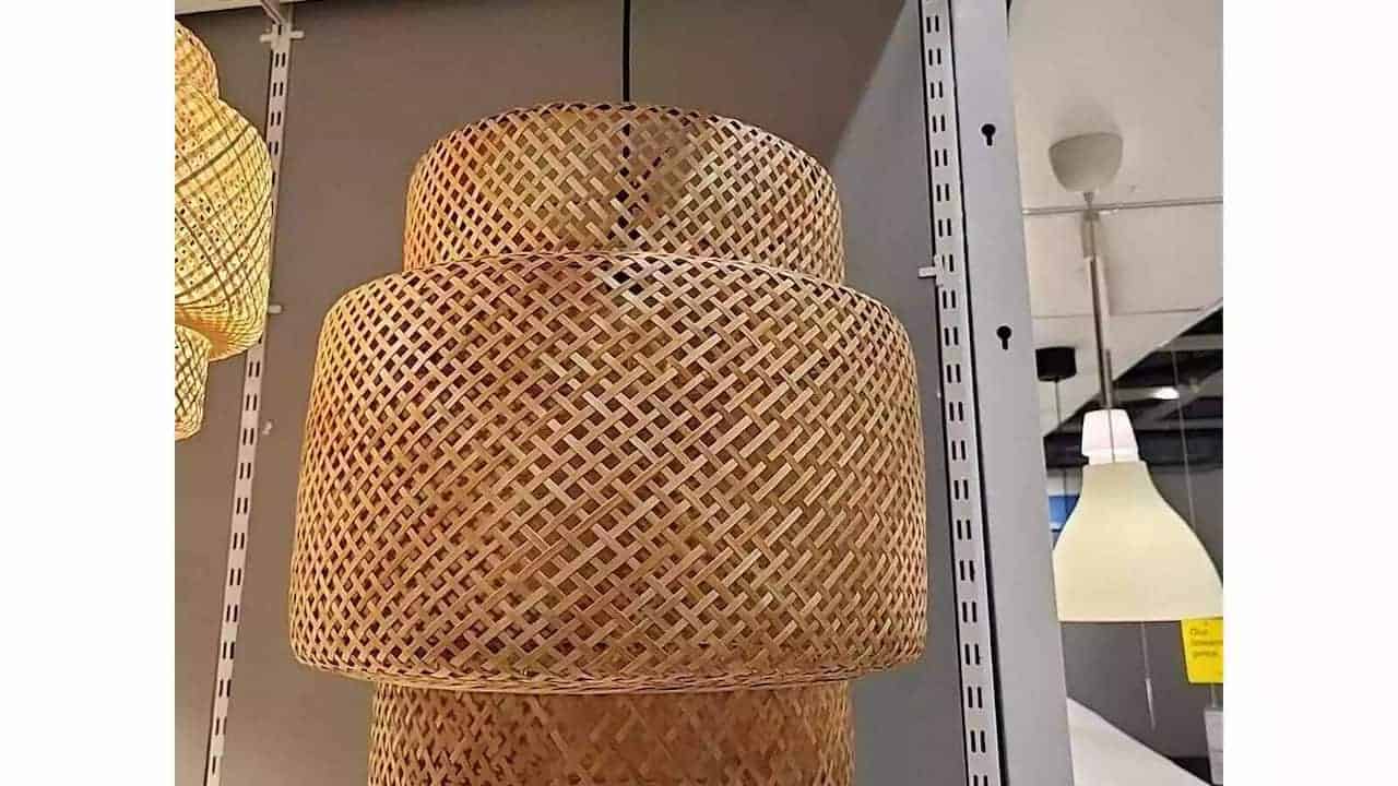 Woven rattan pendant lamp with a double-layered cylindrical design, suspended from the ceiling in a lighting showroom