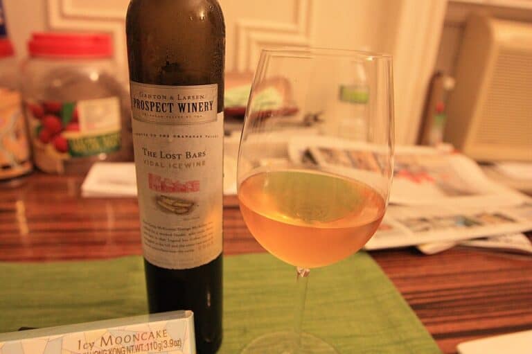 A wine glass and a bottle of wine on a table.