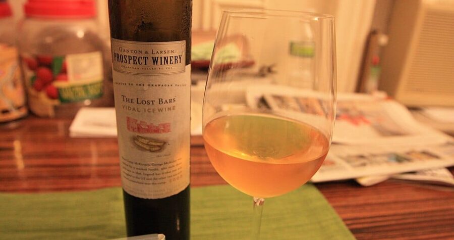 A wine glass and a bottle of wine on a table.