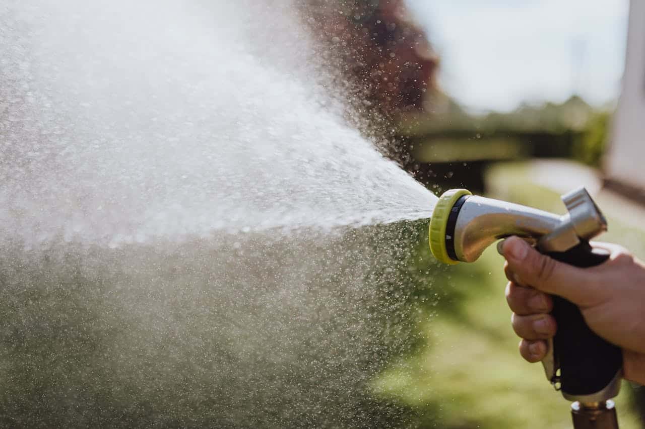 Close-Up Photo of a Person Using a Spray Hose