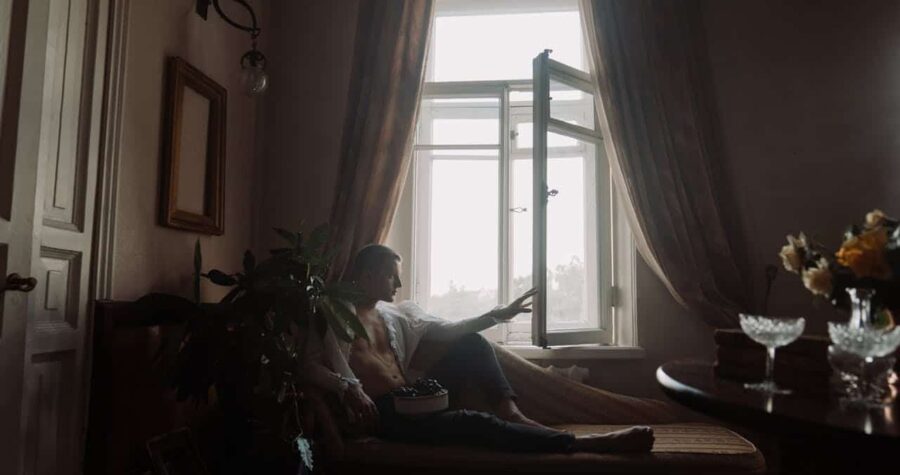 Person Lying on Bed Near Window