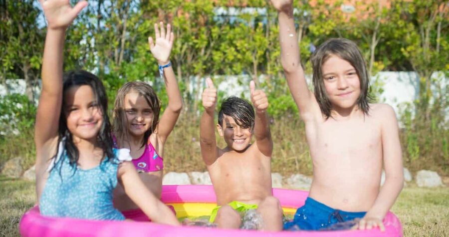 Kids Wearing Swimwear Sitting on Pink and Yellow Inflatable Swimming Pool