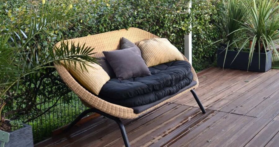 Cozy rattan sofa with cushions in tropical garden
