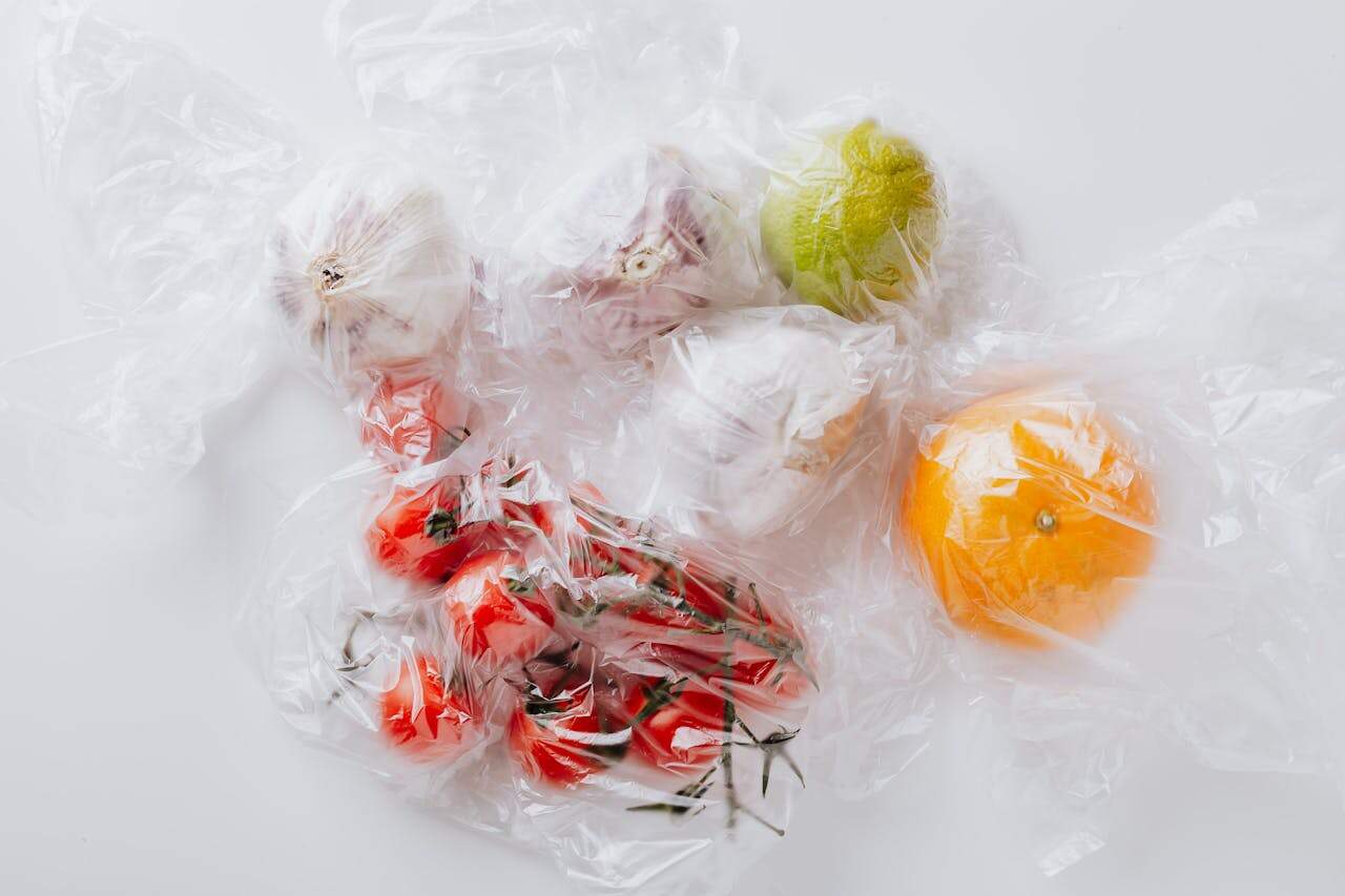 Assortment of fresh vegetables and fruits covered with plastic bags