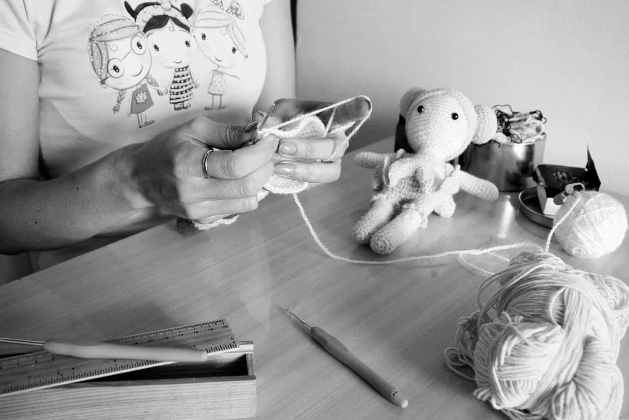 Grayscale Photo of Person Holding Pen and Book