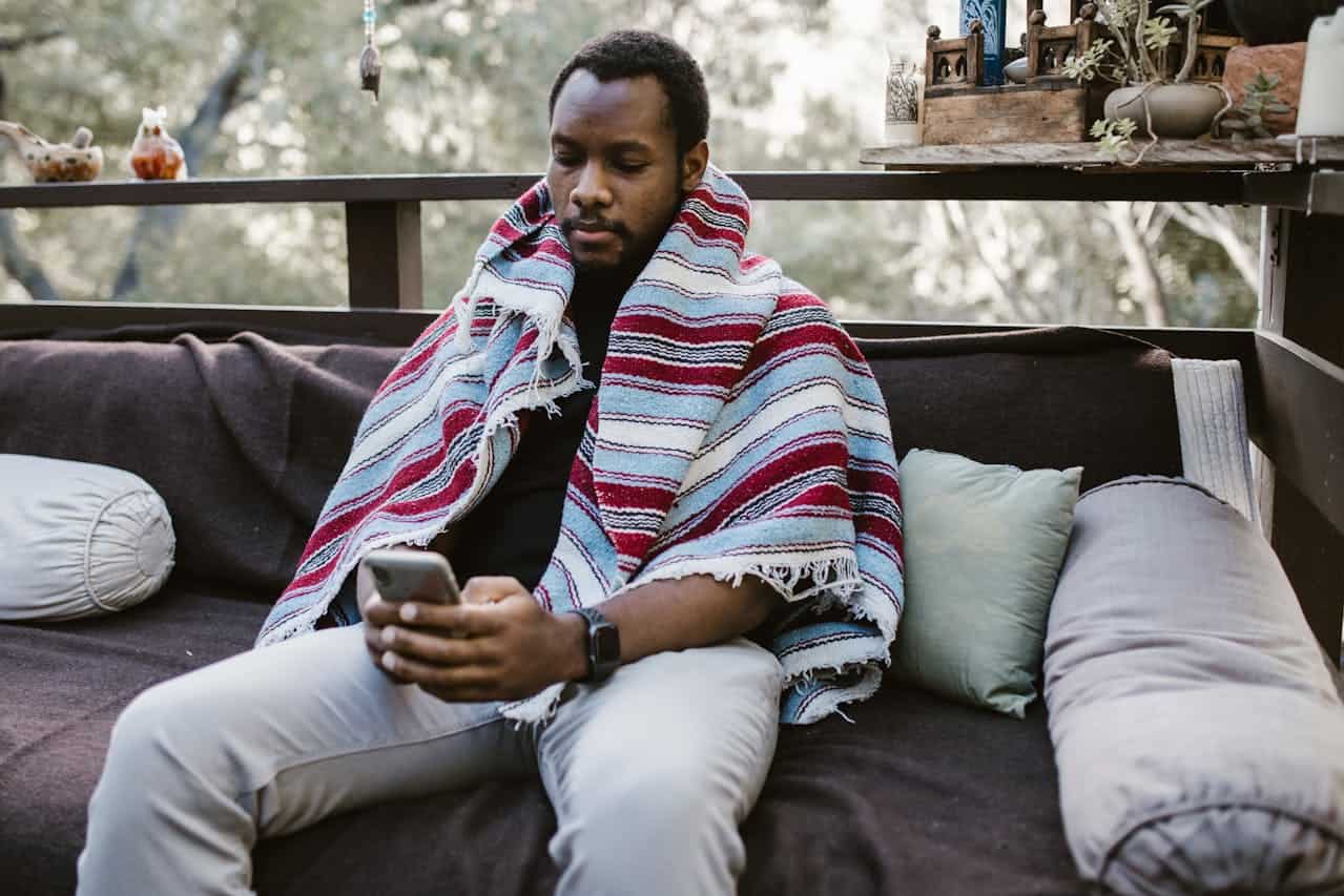 Man Sitting Using His Smartphone